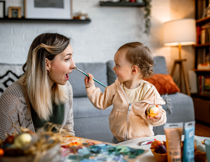 Eine Mutter und ihre junge Tochter bemalen gemeinsam Ostereier