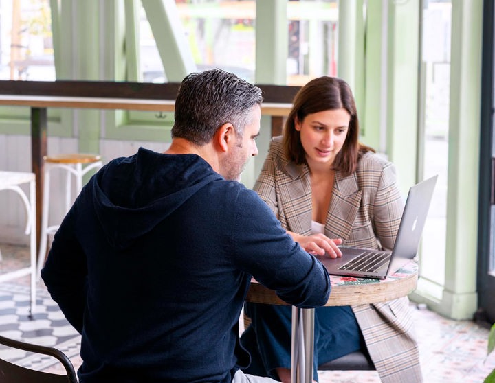 Een man en een vrouw kijken naar een laptop