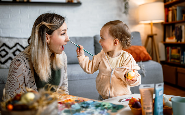 Eine Mutter und ihre junge Tochter bemalen gemeinsam Ostereier