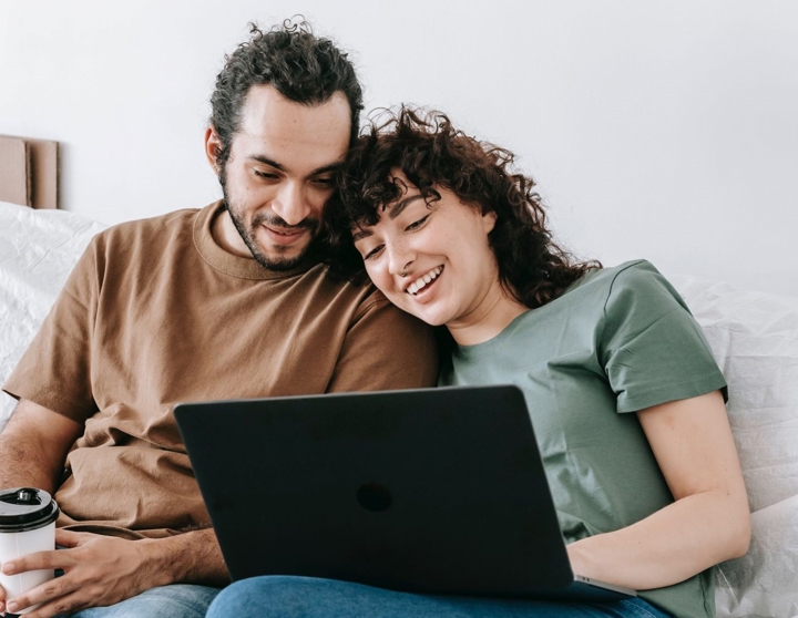 lykkelig par foran en bærbar datamaskin