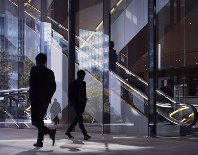 People walking in an office building with an escalator