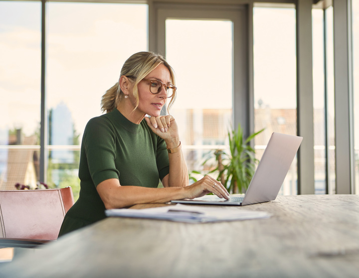 Mevrouw kijkt naar haar laptop