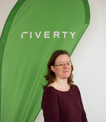 picture of Susanne Rosenberg in front of a Riverty flag 