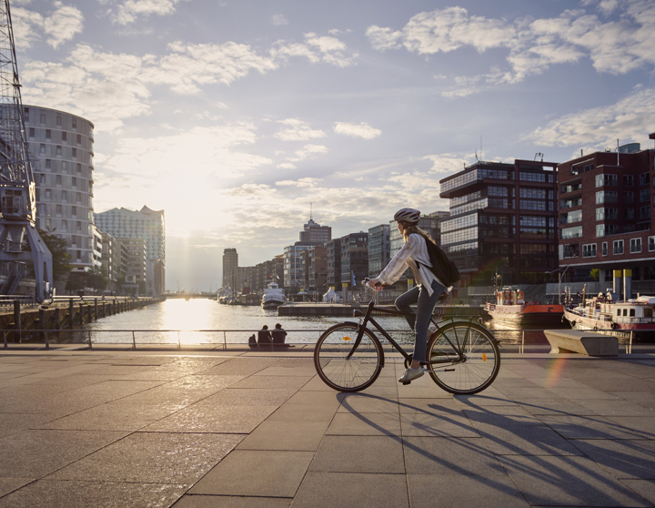 Frau fährt am See auf einem Fahrrad