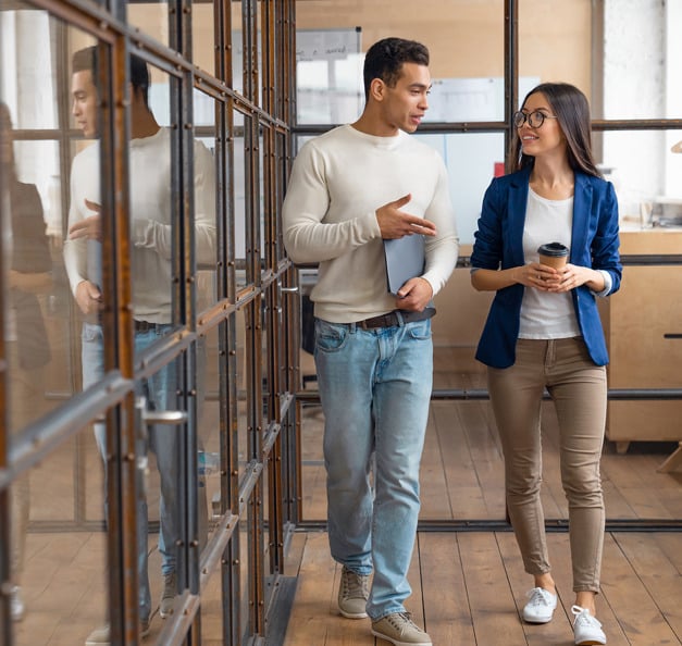 Zwei Personen in einem modernen Büro, welche sich unterhalten