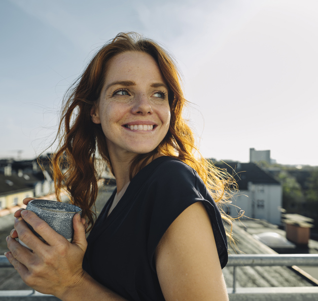 woman smiling and holding a cup 