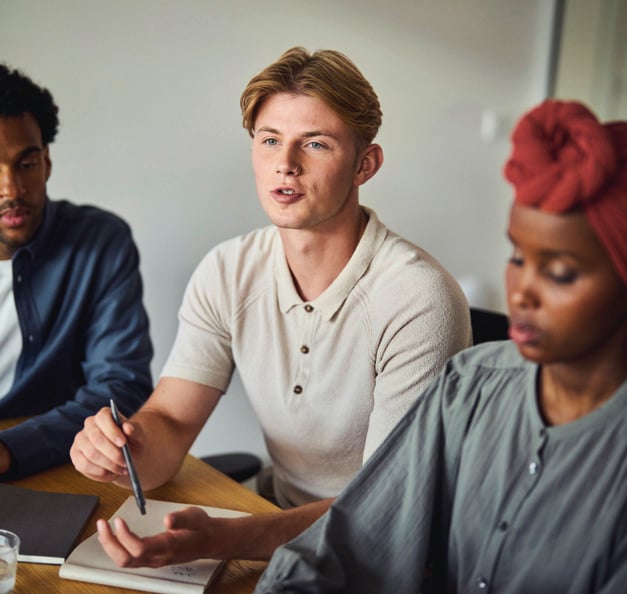 drei Studierende im Klassenraum