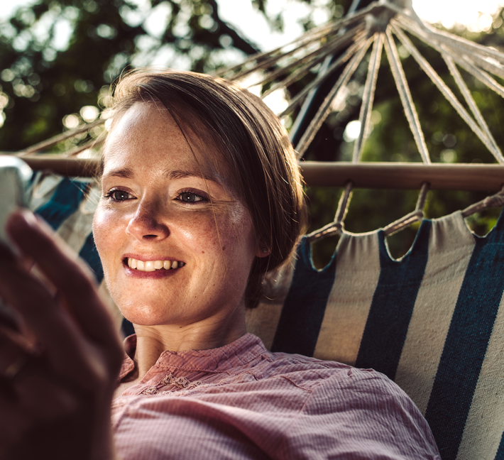 En smilende kvinde ser på en tablet