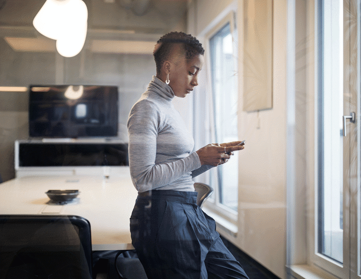Frau mit Smartphone in einem modernen Büro