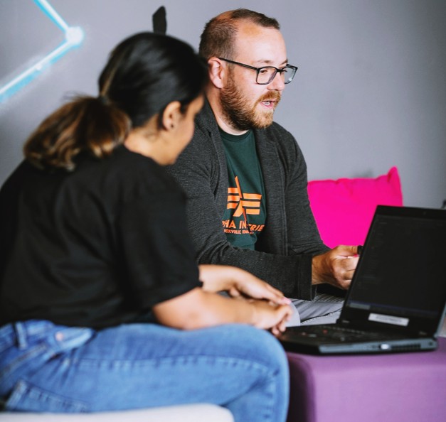 meera and a guy in front of a laptop