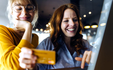 Junge Frauen beim Bezahlen mit ihrer Kreditkarte
