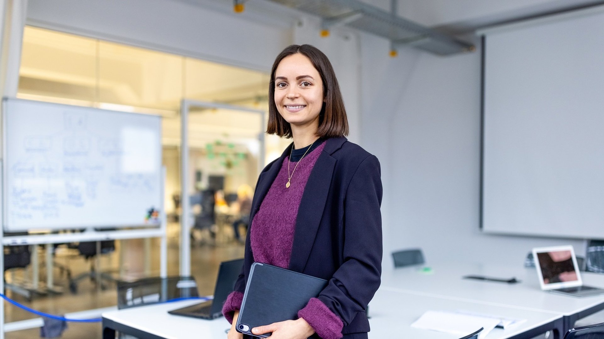 a teacher in a classroom smiling into the camera