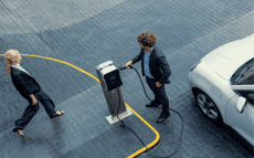 Two drivers prepare to charge their EV vehicle