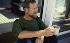 Man på en plats med kaffe i handen