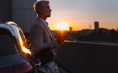A man charges his EV automobile