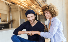 Frau und Mann treffen freundschaftlich mit Händen gegeneinander