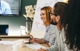 Iloiset kollegat ryhmäkokouksessa puhuvat paneelijohtajasta