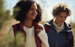 Kaksi naista kävelevät ulkona luonnossa