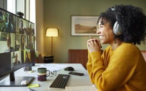 Frau mit Kopfhörern vor einem Computer in einem Online-Meeting