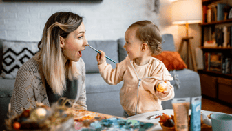 Eine Mutter und ihre junge Tochter bemalen gemeinsam Ostereier