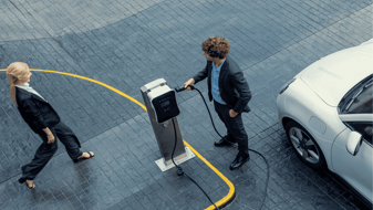 Two drivers prepare to charge their EV vehicle 