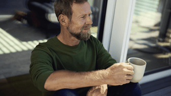 Man på en plats med kaffe i handen