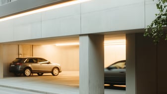 Hell beleuchtetes Parkhaus mit mehreren geparkten Autos.