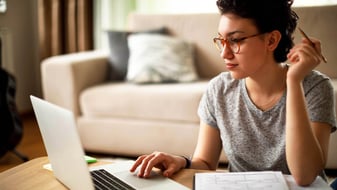 A young woman is researching the topic of insolvency proceedings on her laptop computer.