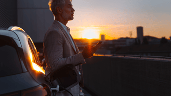 A man charges his EV automobile