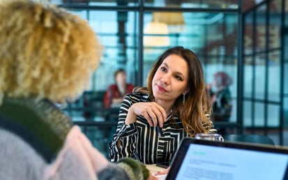Eine junge Frau sitzt mit ihrer Anwältin im Büro und bespricht die Rechtslage der erhaltenen Inkassokosten