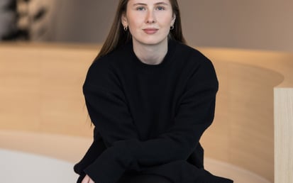 Polina Dmitrenko, External Communications Managerin DACH bei Riverty, sitzend in einem modernen Bürointerieur.