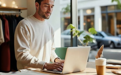 Man behind laptop next to a street