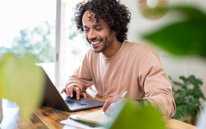 Junger Mann sichtlich entspannt am Laptop - ohne Stress 