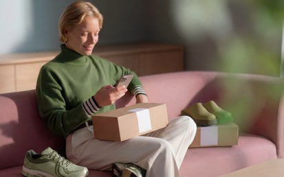 A woman is sitting on the couch and looking at her phone.