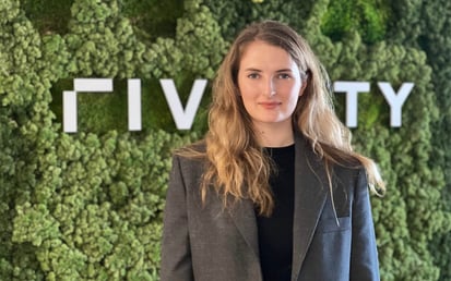Anna Albert standing in front of a Riverty sign
