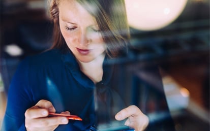 Jonge vrouw kijkt naar haar betaalpas terwijl ze online aan het shoppen is 