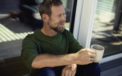 Man på en plats med kaffe i handen