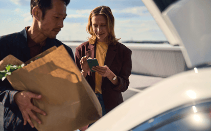 Junge Frau, die neben ihrem Auto steht