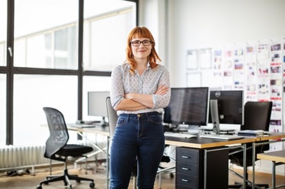 woman smiling into the camera (you can see an office behind her)
