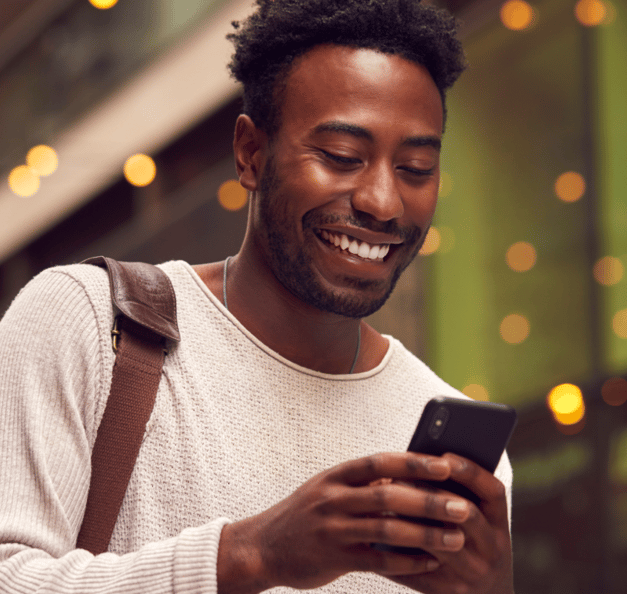 Man holding his phone and smiling 