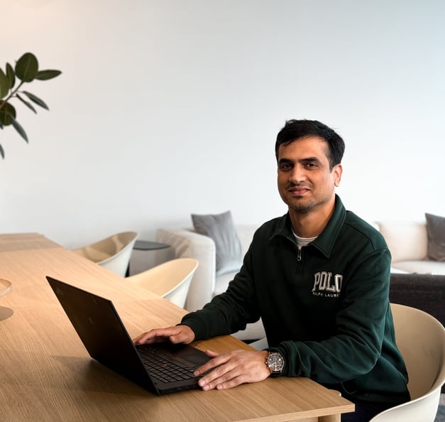 A man with short dark hair sitting behind the desk