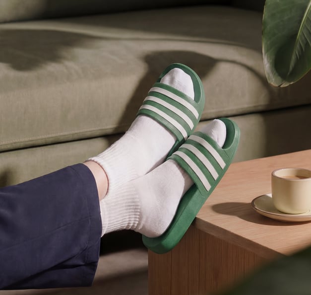 Füße in Pantoffeln auf dem Tisch