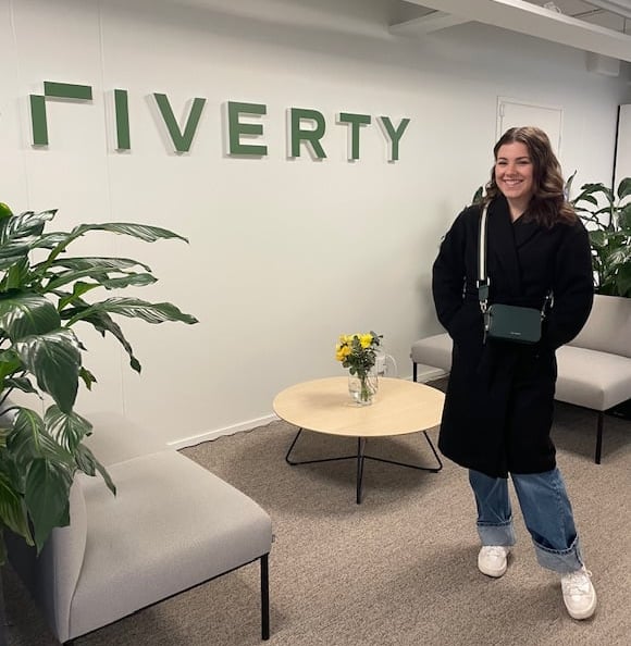Thelma standing in front of Riverty's sign