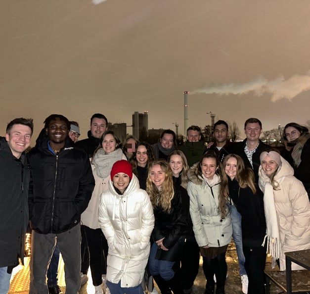 Ein Gruppenfoto im Freien von Timothy und 17 anderen Mitarbeitenden von Riverty