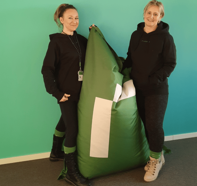 Antonina and her colleague standing next to a Riverty beanbag
