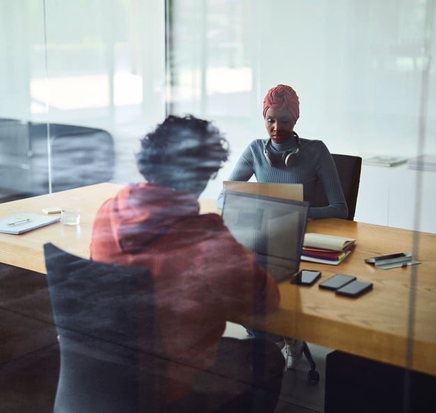 Zwei Personen am Schreibtisch, die an Laptops arbeiten