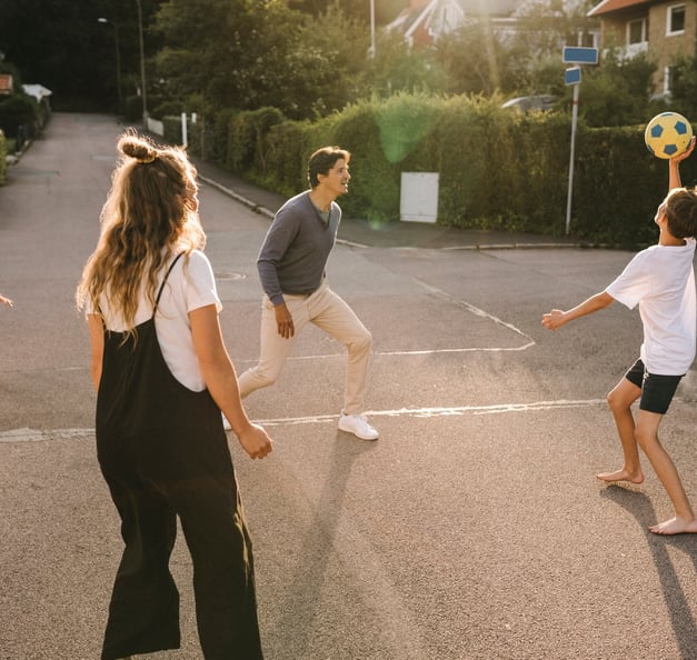 Family playing outside with a ball.