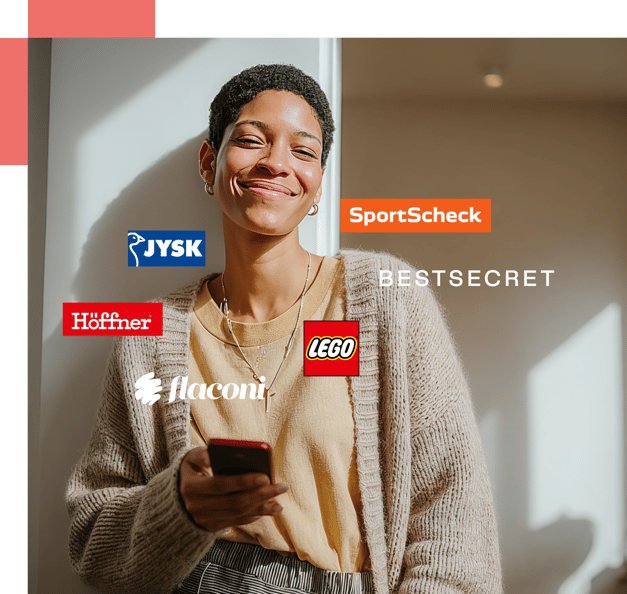 Young woman holding her phone, smiling, while shopping online. Several online shop logos are placed around her: Jysk, Sportscheck, Höffner, Bestsecret, flaconi and Lego.