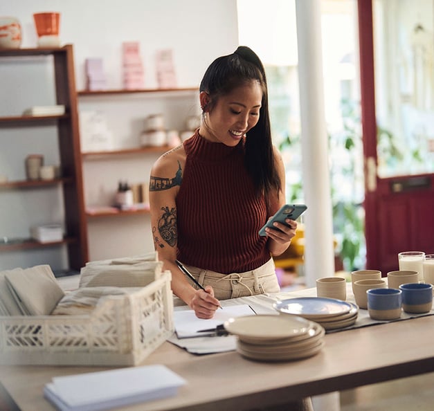 Woman finalizing orders and checking her phone.