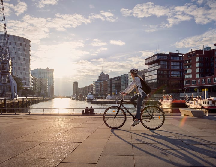Frau fährt am See auf einem Fahrrad